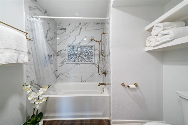 a view of a room with wooden floor and a ceiling fan
