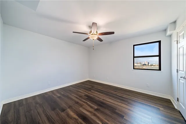 a view of room with wooden floor and ceiling fan
