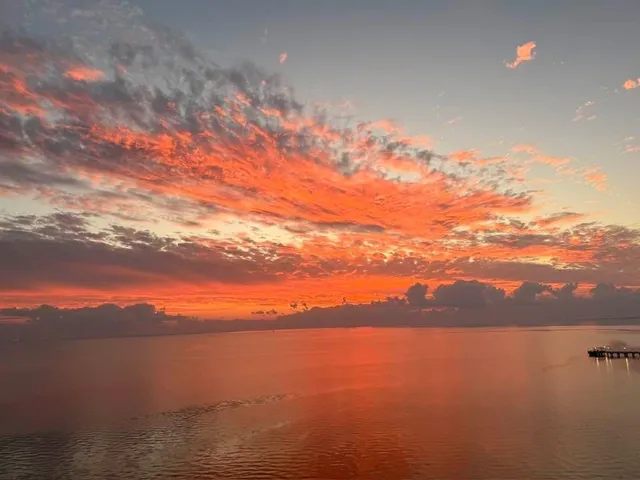 a view of workspace with stainless steel appliances wooden floor and chair