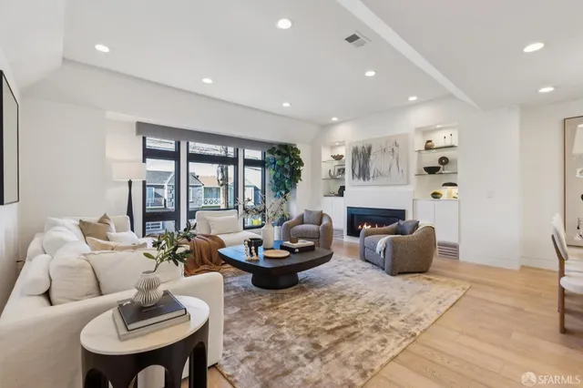 a living room with fireplace furniture and a large window