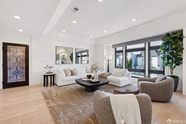 a living room with furniture potted plant and a large window