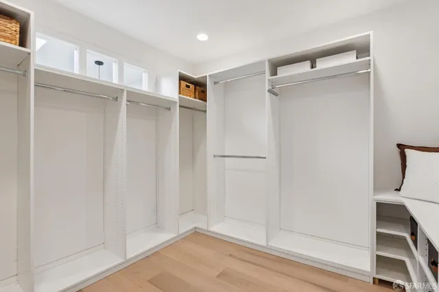 a view of walk in closet with empty racks
