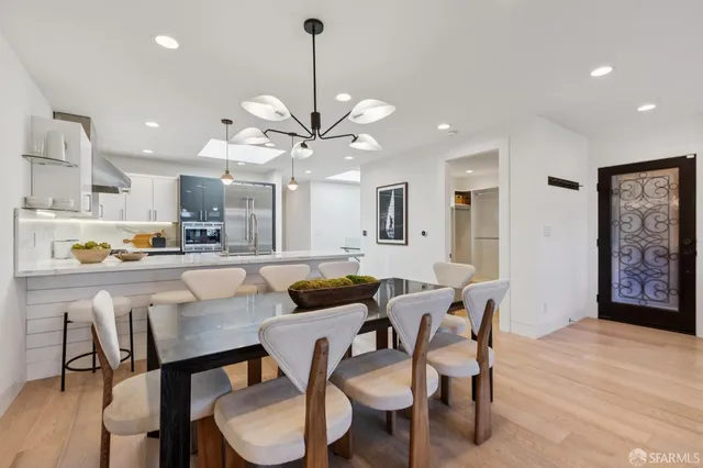 a view of a dining room and livingroom with furniture wooden floor a chandelier