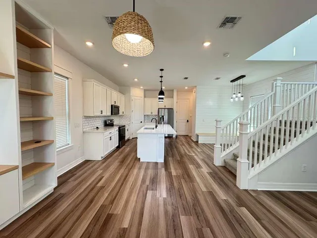 a kitchen with a stove and wooden floor