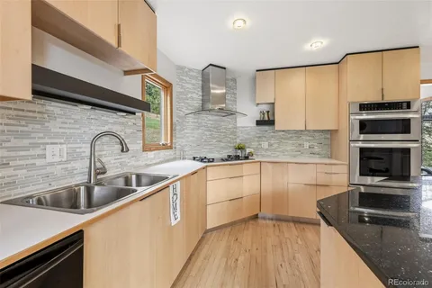 a kitchen with stainless steel appliances granite countertop a sink and a stove