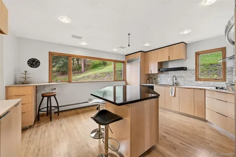 a kitchen with stainless steel appliances granite countertop sink stove and wooden floor