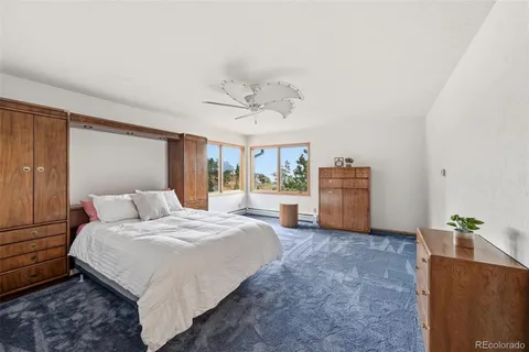 a bedroom with a large bed and ceiling fan
