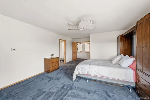 a bedroom with a large bed and a chandelier