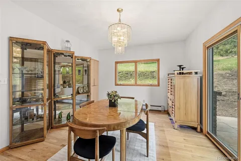 a dining room with furniture a chandelier and wooden floor