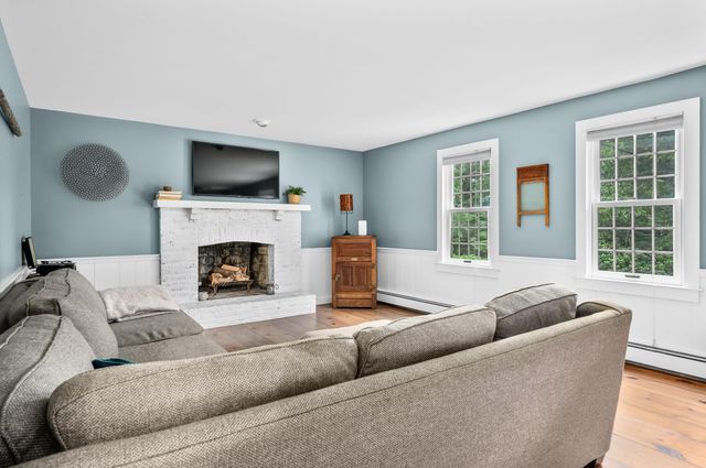 a living room with furniture a flat screen tv and a fireplace