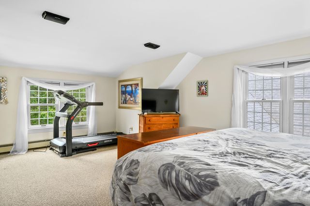 a bedroom with a bed and large windows