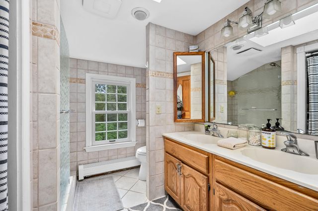 a bathroom with a double vanity sink mirror and a bathtub