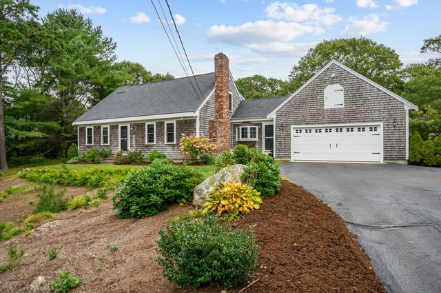 a view of a house with a yard and potted plants
