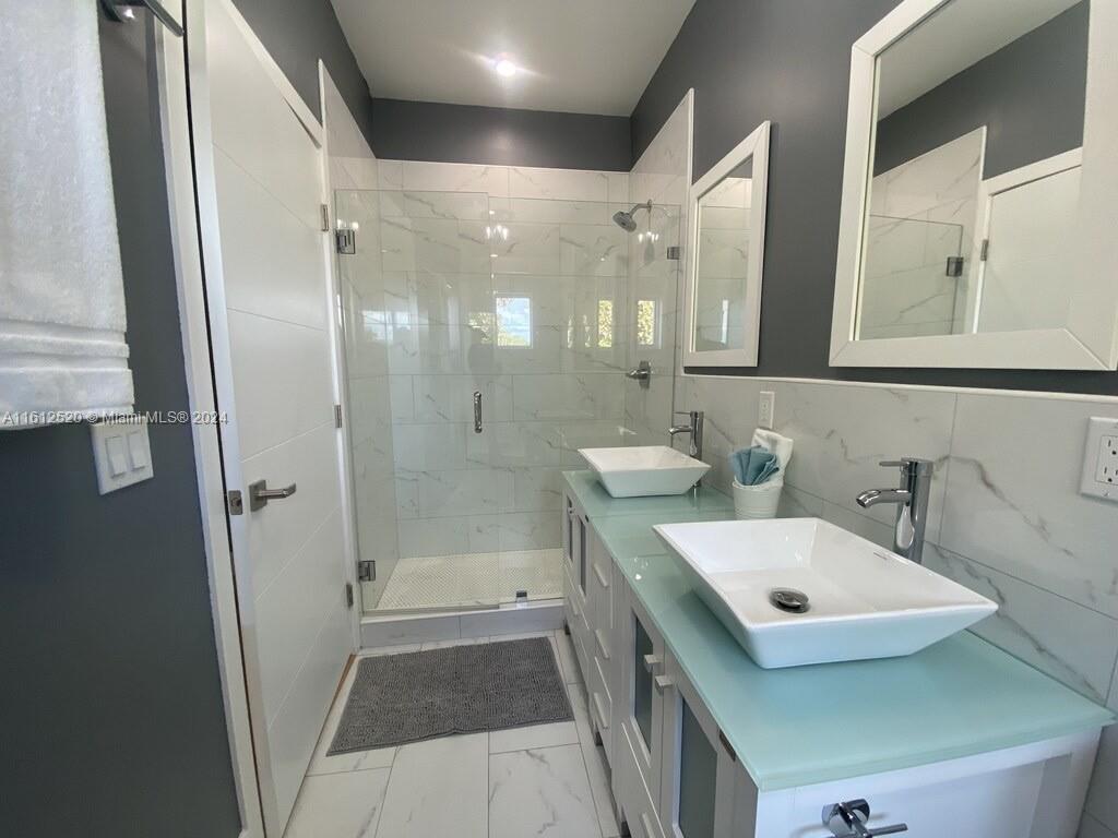3445 Southwest 14th Street, Unit 3445 Miami, FL 33145 - Photo 18 of 52 a bathroom with a double vanity sink mirror double and shower
