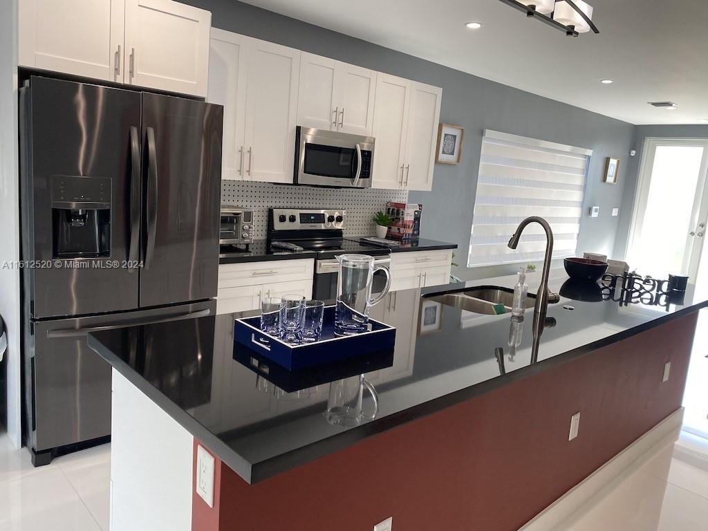 3445 Southwest 14th Street, Unit 3445 Miami, FL 33145 - Photo 38 of 52 a kitchen with a refrigerator a stove a sink and a microwave