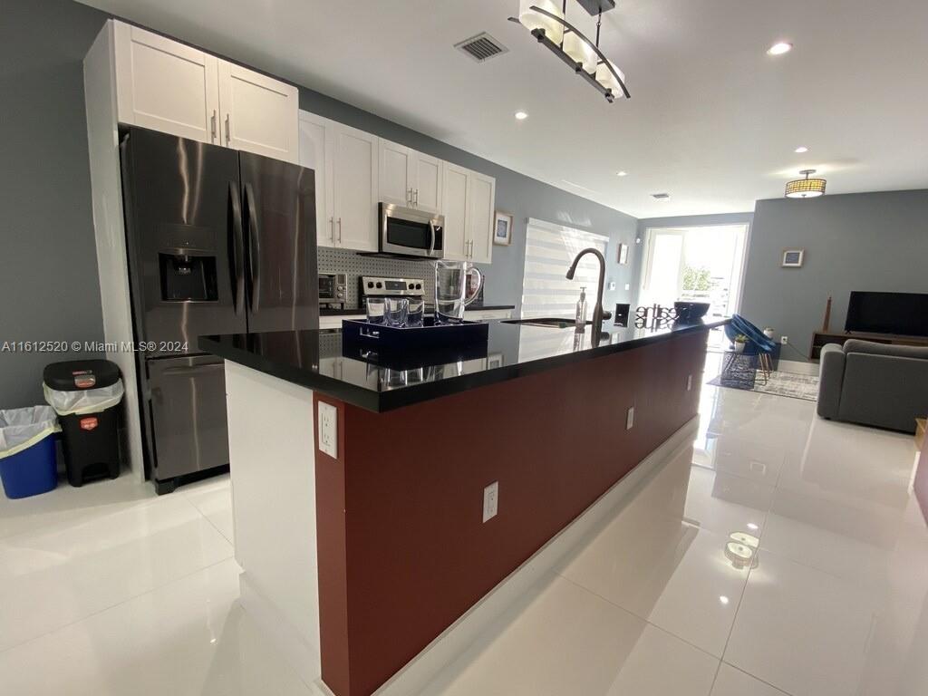 3445 Southwest 14th Street, Unit 3445 Miami, FL 33145 - Photo 41 of 52 a kitchen with stainless steel appliances a sink dishwasher a refrigerator a microwave oven with granite countertops and cabinets