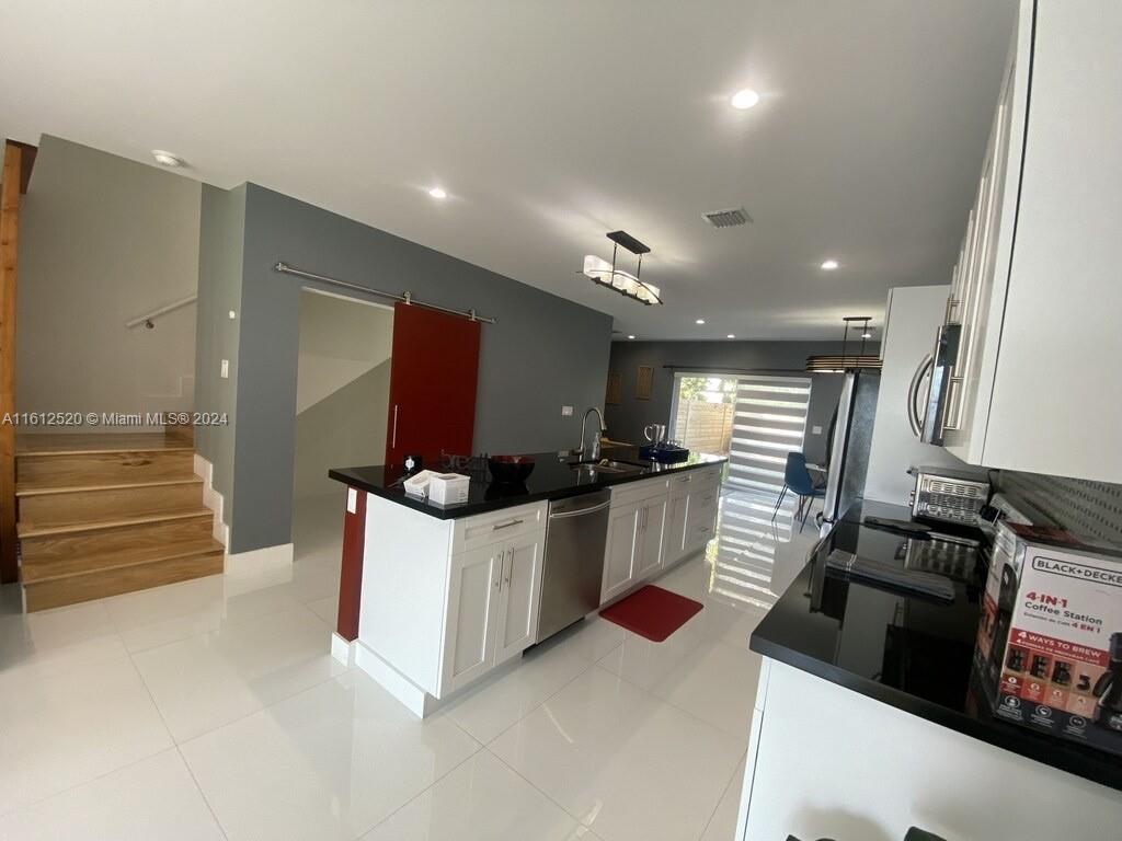 3445 Southwest 14th Street, Unit 3445 Miami, FL 33145 - Photo 42 of 52 a kitchen with stainless steel appliances kitchen island granite countertop a stove and a sink