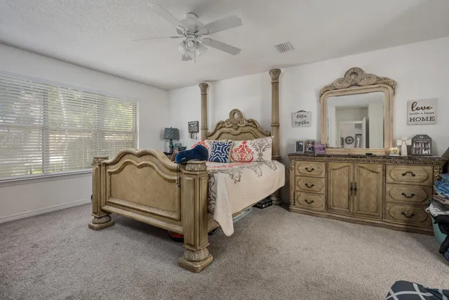 a bed sitting in a bedroom next to a window