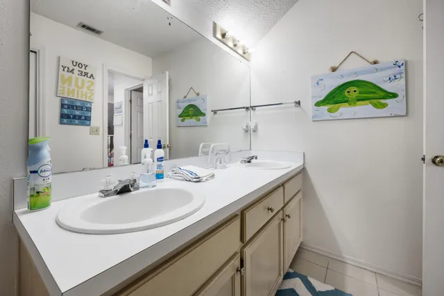 a view of a house with a yard and large tree
