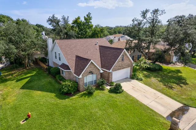 a view of a patio with table and chairs potted plants and a large tree