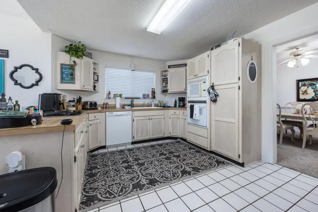 a kitchen with white cabinets and white appliances