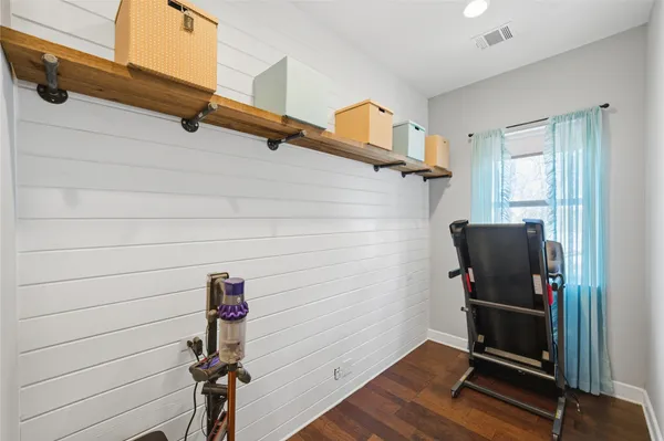 a view of a hallway with wooden floor and a cabinet
