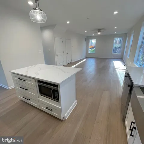 a kitchen with a stove and wooden floor