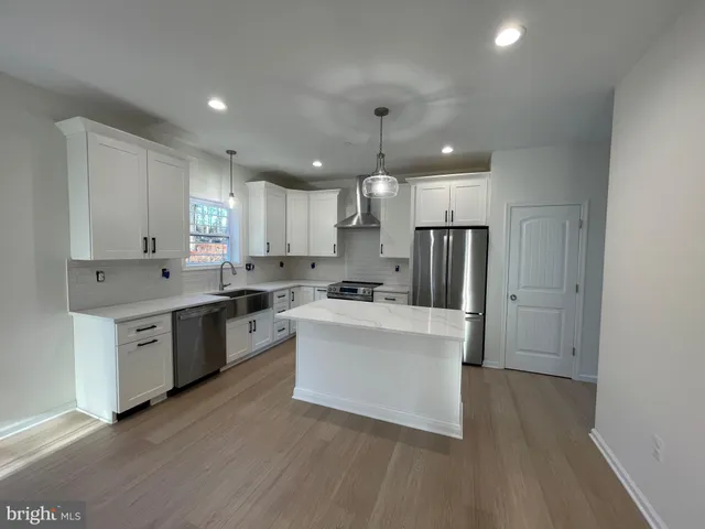 a kitchen with stainless steel appliances a refrigerator sink and cabinets