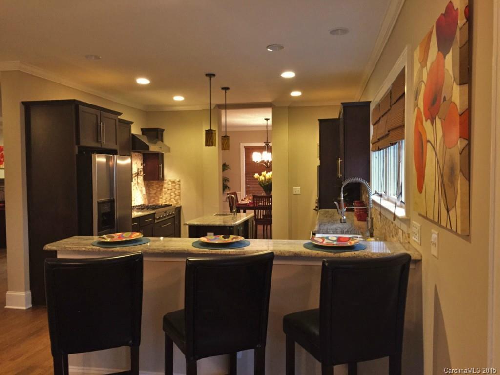 521 Grandin Road Charlotte, NC 28208 - Photo 5 of 23 a kitchen with a table chairs refrigerator and cabinets