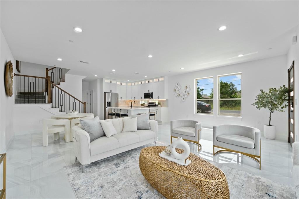 Living area with recessed lighting and stairway