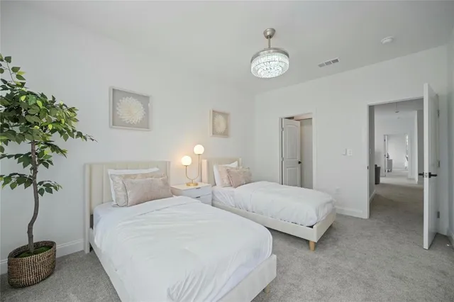 a bedroom with two beds and a potted plant