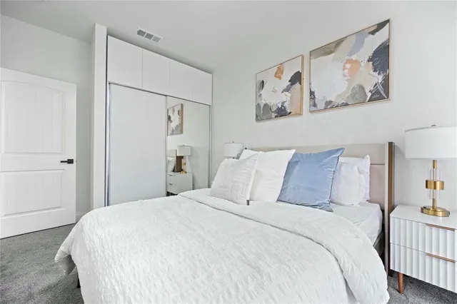 a bedroom with a bed and a white wall painting