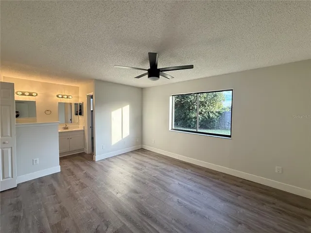 a view of empty room with wooden floor and window