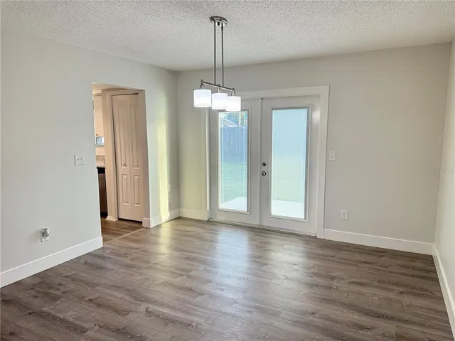 a view of a room with wooden floor chandelier and window
