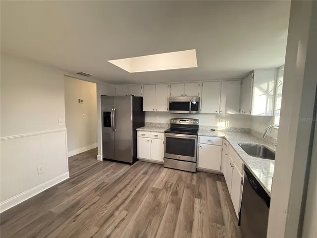 a kitchen with a refrigerator a stove top oven a sink and dishwasher