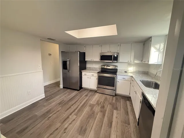 a kitchen with a sink a refrigerator and cabinets