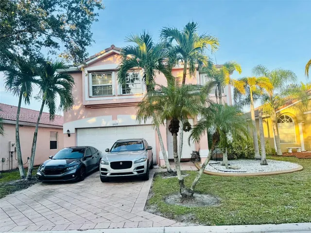 a couple of cars parked in front of a house