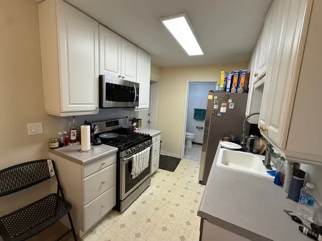 a bathroom with a granite countertop toilet sink and mirror