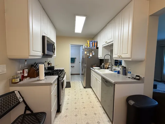 a kitchen with a refrigerator sink and wooden floor