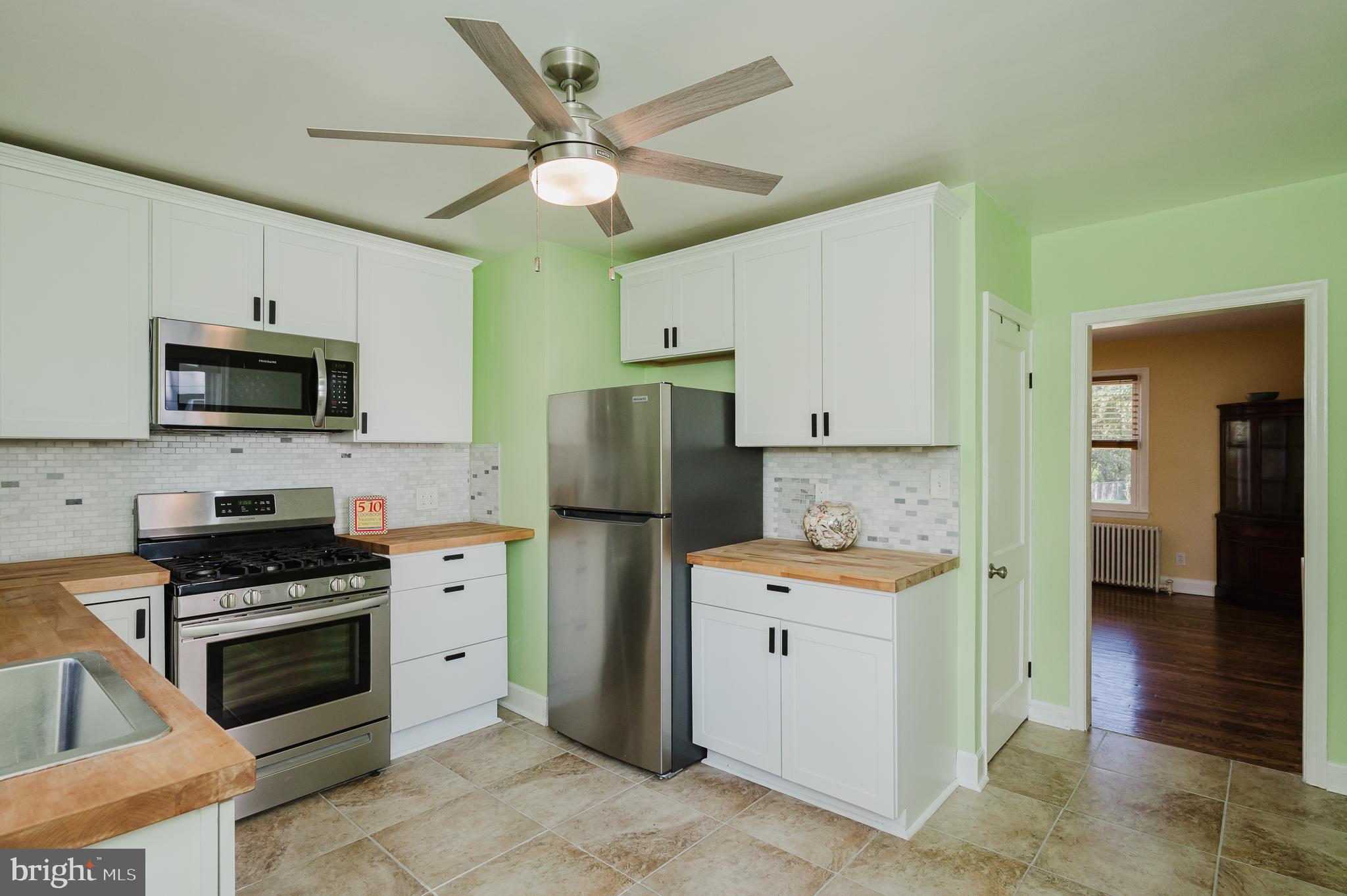 5501 Catalpha Road Baltimore, MD 21214 - Photo 11 of 40 a kitchen with a sink a stove and refrigerator