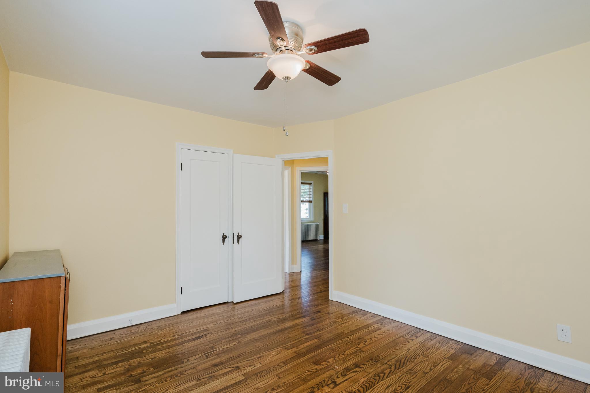 5501 Catalpha Road Baltimore, MD 21214 - Photo 14 of 40 an empty room with wooden floor ceiling fan and window