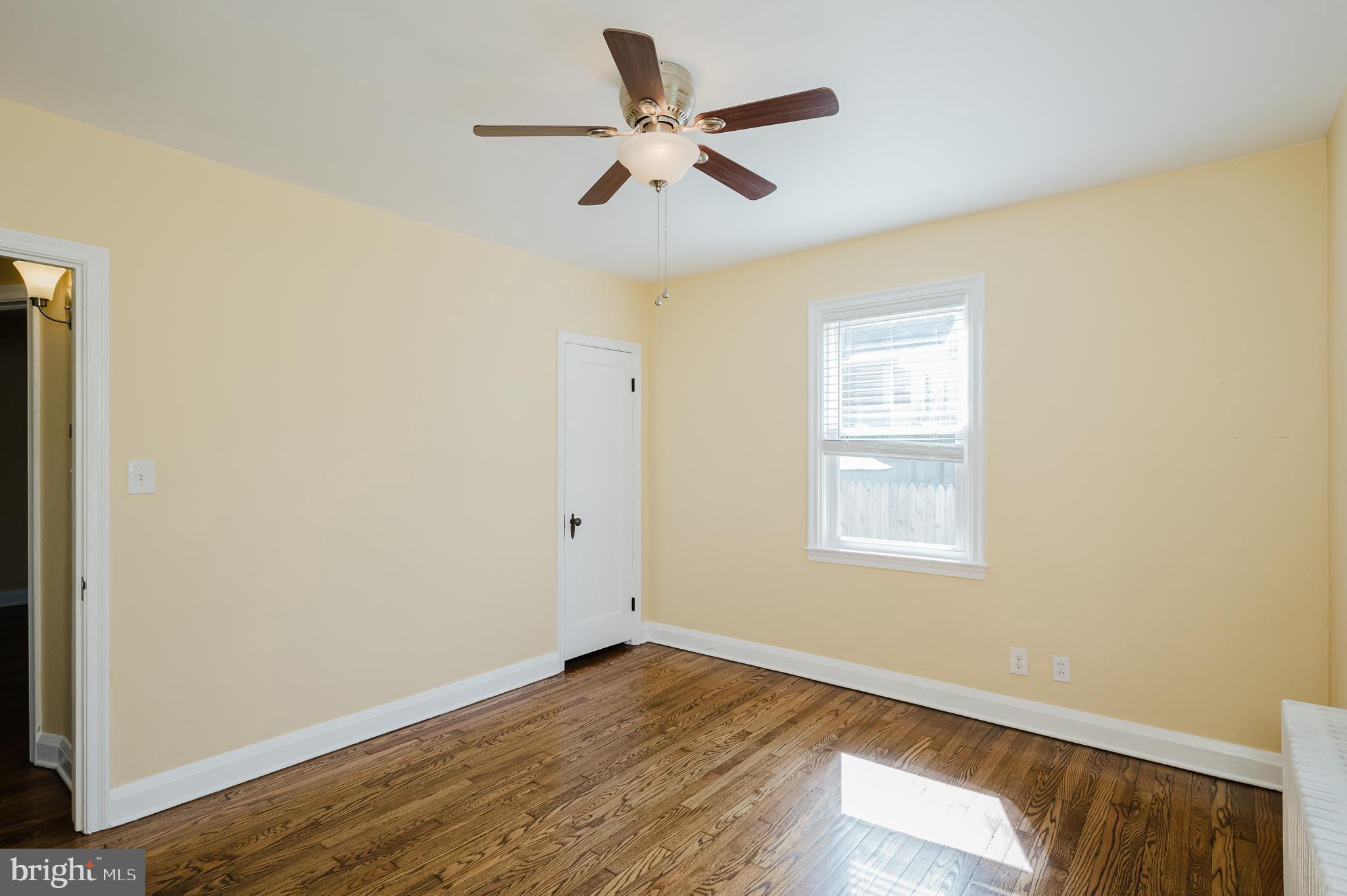 5501 Catalpha Road Baltimore, MD 21214 - Photo 16 of 40 a view of an empty room with wooden floor and a window