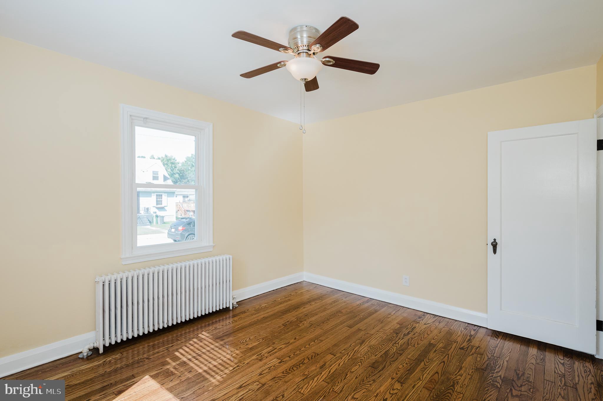 5501 Catalpha Road Baltimore, MD 21214 - Photo 18 of 40 an empty room with wooden floor and windows