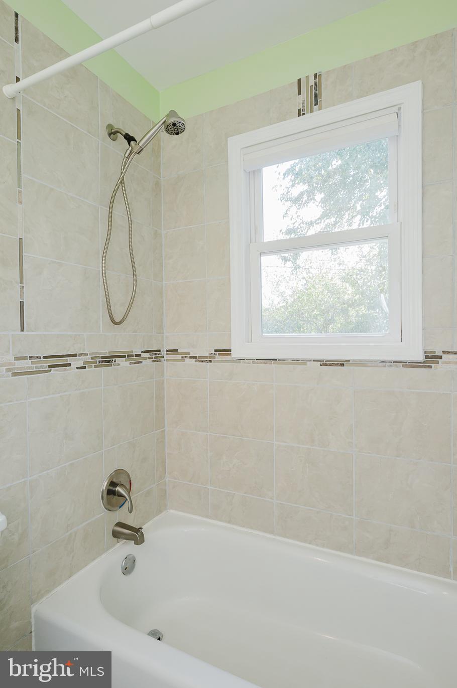 5501 Catalpha Road Baltimore, MD 21214 - Photo 20 of 40 a bathroom with a bath tub and a shower