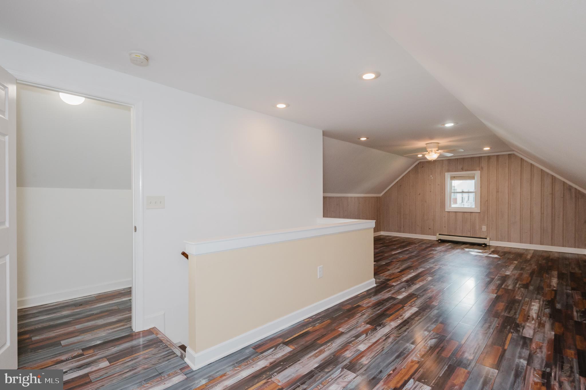 5501 Catalpha Road Baltimore, MD 21214 - Photo 29 of 40 a view of hallway with stairs and wooden floor