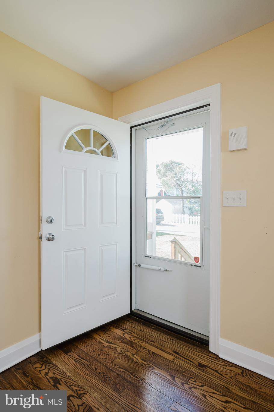 5501 Catalpha Road Baltimore, MD 21214 - Photo 4 of 40 an empty room with wooden floor and windows