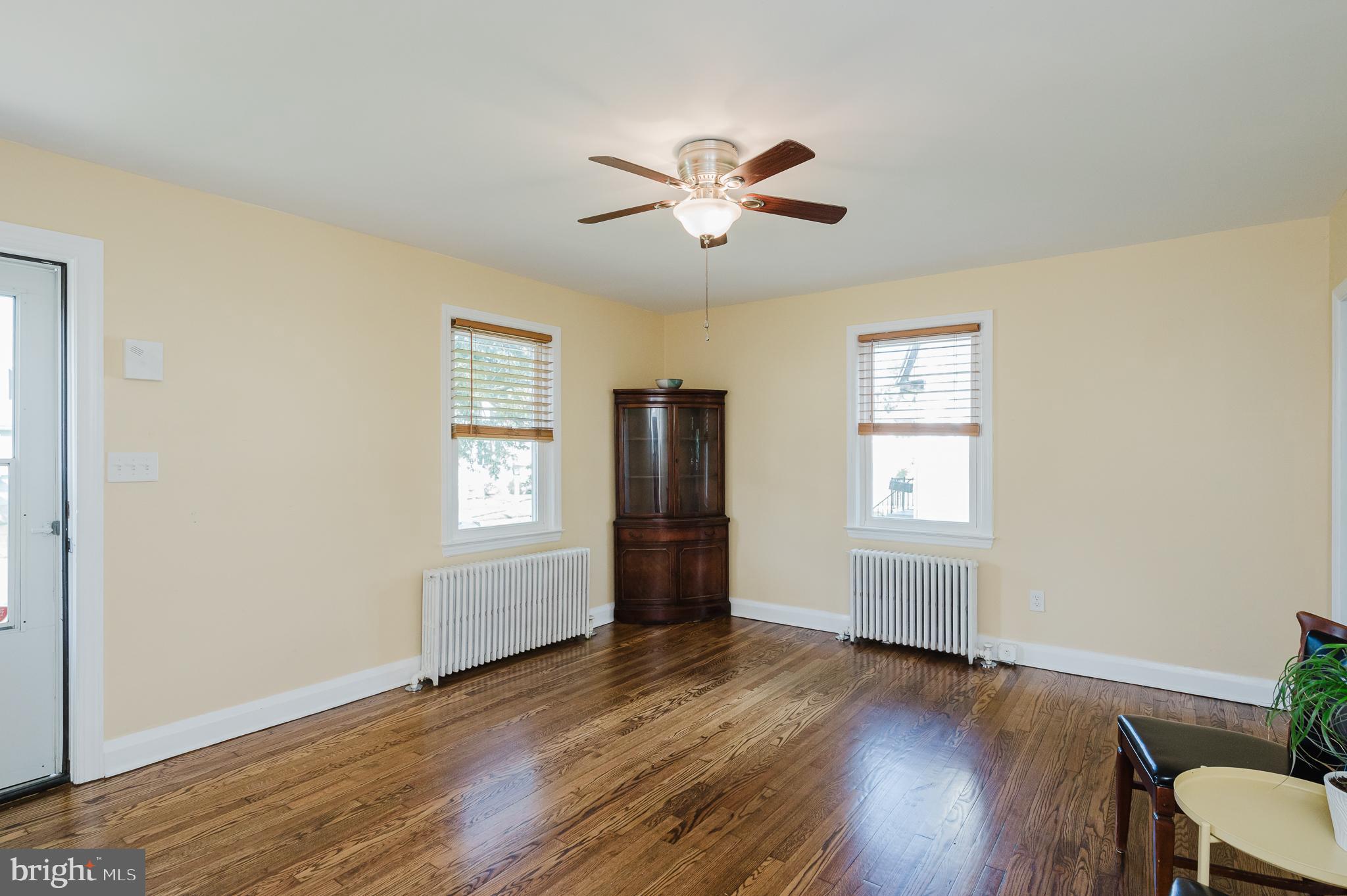 5501 Catalpha Road Baltimore, MD 21214 - Photo 5 of 40 a view of empty room with wooden floor and fan