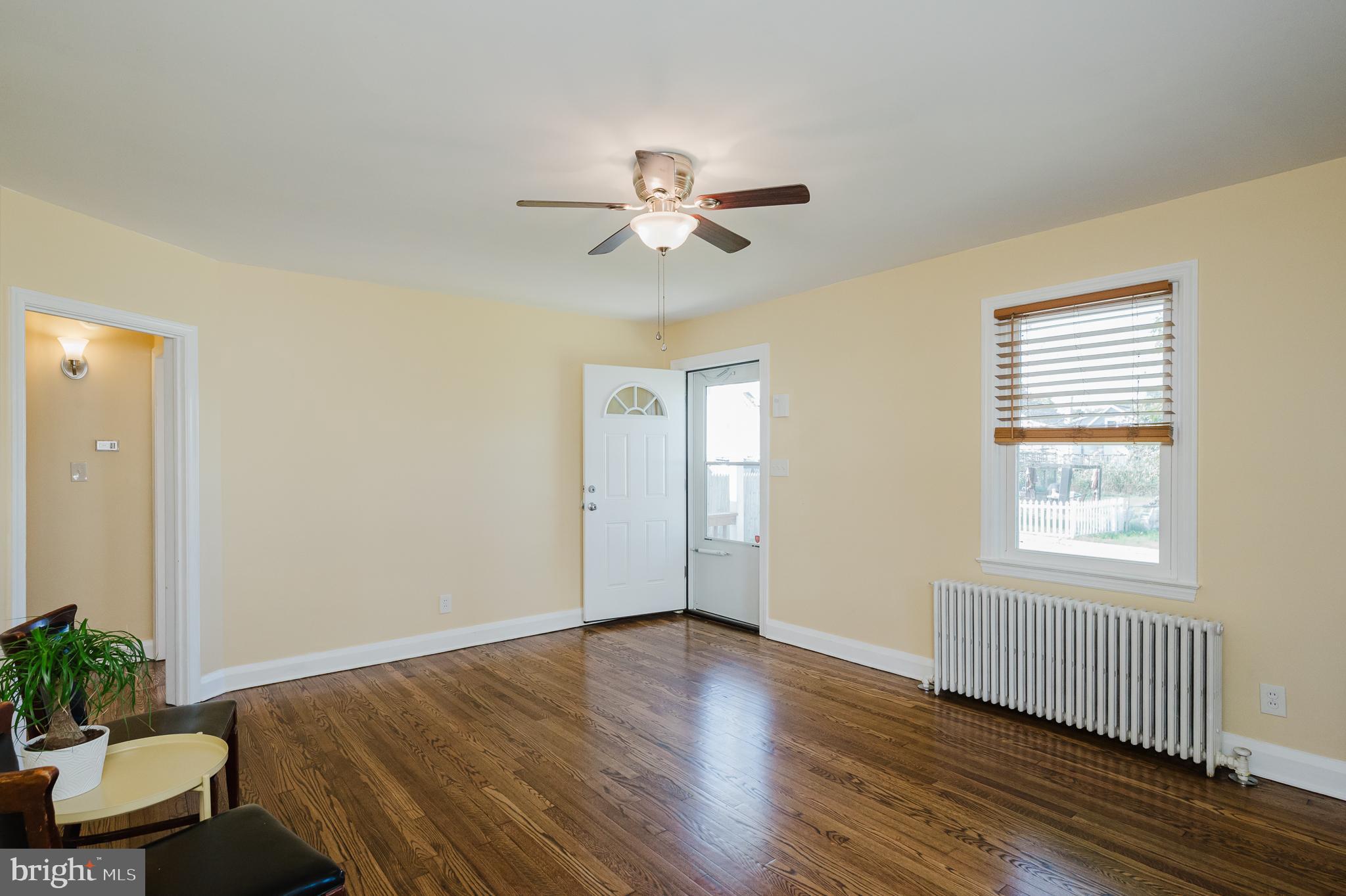 5501 Catalpha Road Baltimore, MD 21214 - Photo 6 of 40 a view of an empty room with a window and wooden floor
