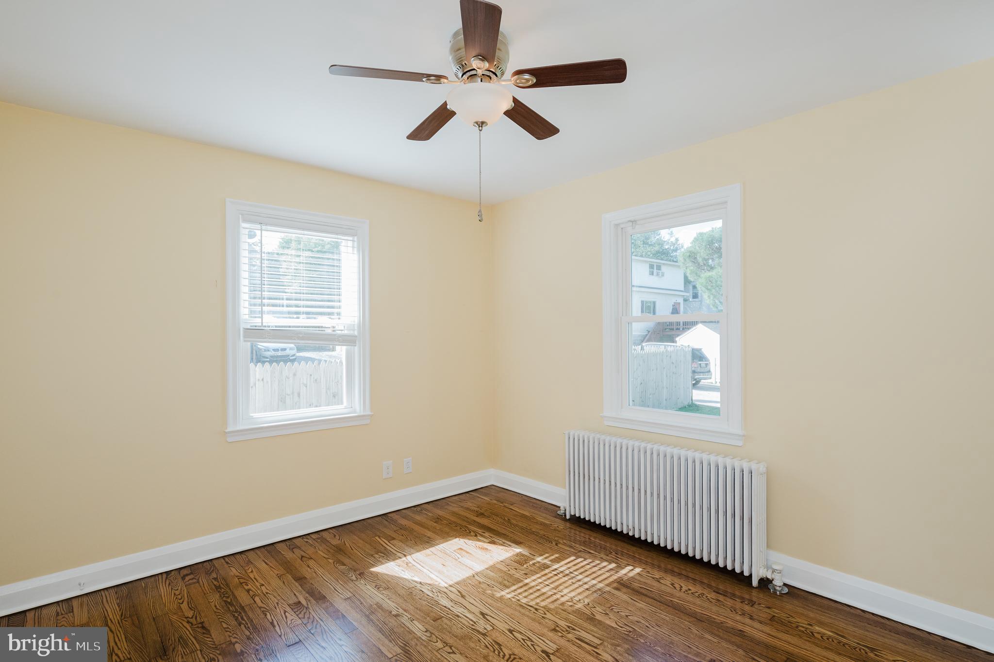 5501 Catalpha Road Baltimore, MD 21214 - Photo 8 of 40 a view of an empty room with wooden floor and a window