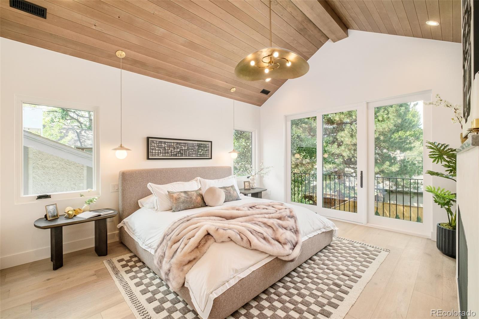 1253 South High Street Denver, CO 80210 - Photo 24 of 46 a bedroom with a large bed and a chandelier